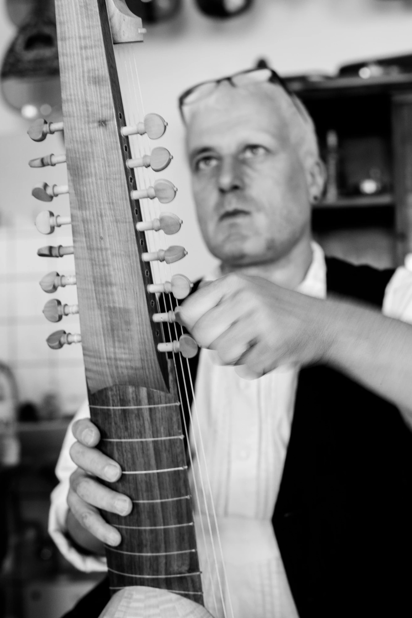 Lautenbauer stimmt ein Saiteninstrument