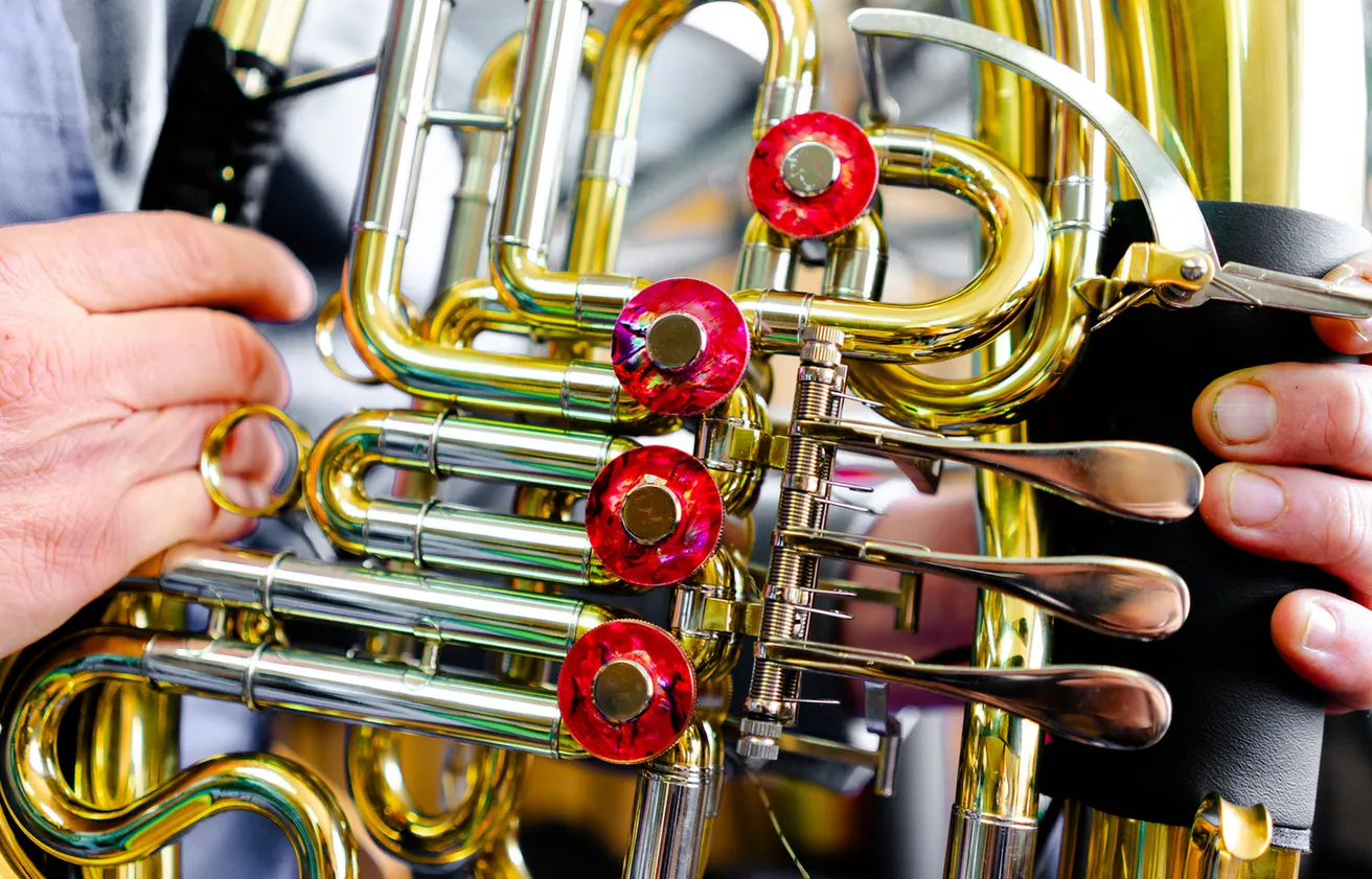 Hände arbeiten an den Ventilen eines Blechblasinstruments