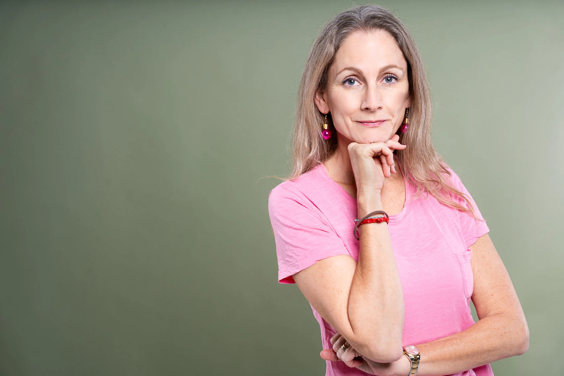 Selbstbewusstes Businessporträt einer Frau vor grünem Hintergrund